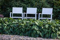 White chairs in shady garden