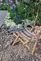Deck chair in pebble and gravel border. A Day at The Seaside RHS Tatton Park Flower Show 2013