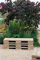 Garden bench made from recycled boards. Cercis canadensis 'Forest Pansy'. The Bees Garden. RHS tatton Park Flower Show 2013