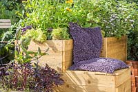 Moveable container with cushioned seat in small suburban garden