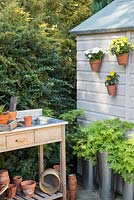 Hanging pots on a shed in a small suburban garden