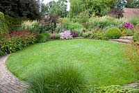 Central circular lawn with mixed borders 