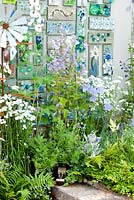 Discarded and recycled materials used to create contemporary garden with sculpture and planting in shades of green, blue and white in the 'Garden Gallery' garden. RHS Tatton Flower Show 2013