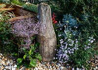 A rowing boat and some driftwood in the coastal themed beach garden, Driftwood gardens