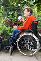 Elderly disabled woman enjoying a cup of tea
