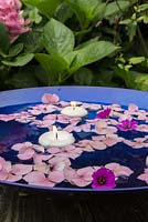 Floating candles accompanied by Hydrangea and Geranium flowers