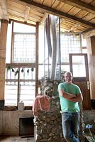 Man inside barn with pizza oven he created