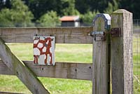Painted cow on a fence to show where the cows are kept