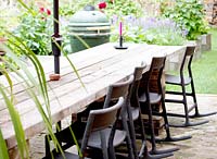 Long table made of recycled wooden boards. Black rocking chairs from IKEA 