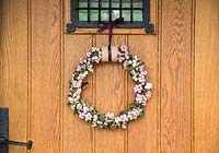 Decorative Pink Snowberry wreath against wooden door