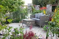 Seating on terrace with planting of  Astilbe, Hosta, Ligularia and Primula vialii