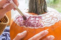 Using a stencil to paint a pattern onto a Pumpkin