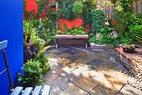 Small town garden with slate tiled floor inset with pebbles 