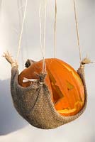 Pumpkin hanging in hessian hammock.