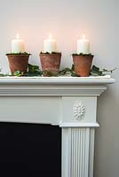 Christmas candle decorations made using terracotta pots and moss