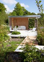 Lounge area built with stones, wood and metal. Juncus effuses  - Soft Rush, Carex pendula - Pendulous Sedge, Luzula sylvatica.