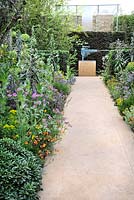 Flowering borders including Echium pininana, Geranium maderense and Geum with pathways and sculpture in The Lucid Garden in The Arthritis Research UK Garden