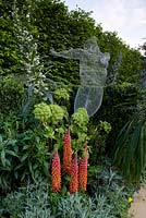 Colourful border with wire sculpture and plants including Echium pinnata and lupins