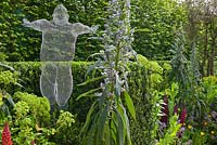 Sculpture 'Libertine' by Michelle Castles in The Arthritis Research UK Garden. Planting includes Angelica gigas, Echium, Lupinus and Buxus sempervirens