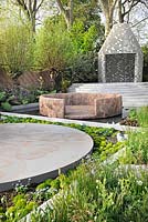 Dry and damp borders, stone circle with inlaid traditional design pattern, mud walled island in pool and pavilion on terraced steps. Key plants include Salix alba pollards, Rheum palmatum, Myosotis arvensis - forget me nots, Helxine soleirolii 'mind your own business', Acaena and Silene fimbriata