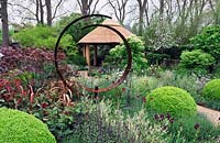Thatched Summer House viewed through circular sculpture. Windows Through Time, RHS Chelsea Flower Show 2013  