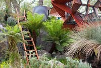 Trailfinders Australian Garden, Chelsea Flower Show 2013. Modern garden studio building with Tree Ferns, ladder and water butt.