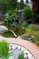 Trailfinders Australian Garden, Chelsea Flower Show 2013. Pond and waterfall in garden with native Australian planting 