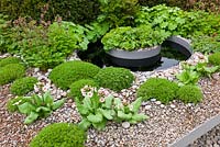 A circular water feature in a split level gravel garden in The First Touch Garden, RHS Chelsea Flower Show 2013 