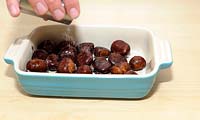 Castanea sativa (sweet chestnut) fruit being prepared for roasting, adding salt. (MR'd)