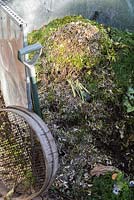 Compost heap with new addition of shredded branches and cuttings