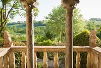 View through columns and over the balcony across surrounding countryside, with lions of red Verona marble sitting on the balustrade.  