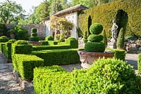 Box parterre with Casita beyond and Italian marble figure of youth on right.