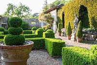 Box parterre with Casita beyond and Italian marble statue of youth against the yew hedge.