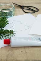 Materials required are adhesive, pine foliage, scissors and paper