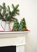 Variety of trees with different decorations on mantelpiece