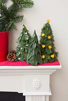 Variety of trees with different decorations on mantelpiece 