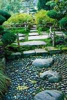 Stone pathway though Japanese garden with bamboo edging and bamboo