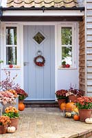 Front door decoration decorated for autumn with squashes, pumpkins, chrysanthemums 