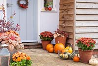 Front door decoration decorated for autumn with squashes, pumpkins,chrysanthemums etc