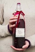Woman holding bottle of sloe gin to give as a gift