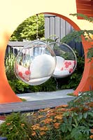 Orange arch with retro designer furniture - planting Achillea Terracotta and Ginkgo biloba.   