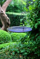 Decorative bird table made from old plate. The garden of Swedish garden designer and editor Ulla Molin 1909-1997 in Hoganas, Sweden, in 2005.