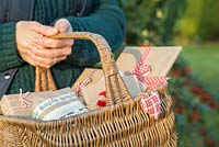 Woman carrying wicker basket full of Christmas presents
