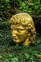 'Appollon Terroriste' - golden head in The Wild Garden. Little Sparta, Dunsyre, Lanark, Lanarkshire. Scotland. 