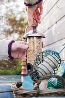 Refilling clean bird feeders with nutritious food