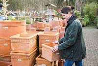Woman browsing variety of terracotta pots  at a garden nursery