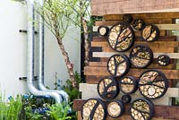 Variety of round insect houses made using natural materials. Wood, Stone, Moss and Dead flower heads. Cornus florida. Show Garden: RBC Blue Water Roof Garden.  