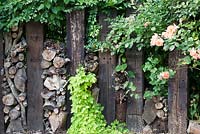 Decorative fencing using wooden sleepers and logs with Rosa 