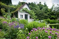 Summer house surrounded by planting including Stachys officinalis, Veronica spicata, Asclepia, Monarda menthifolia, Buxus sempervirens