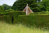 Long meadow grass beside tall yew hedge and hidcote-style pepper-pot roof behind - Cothay Manor, Greenham, Somerset, England summer, late June 